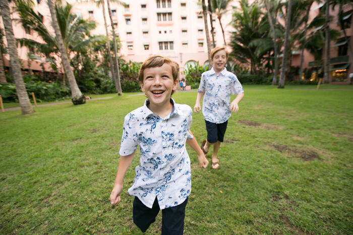 Two brothers running and laughing on the lawn