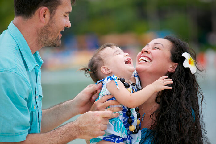 Father and mother laughing with their toddler