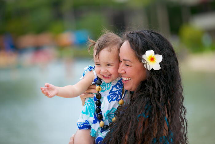 Mother and toddler cheek to cheek, both smiling